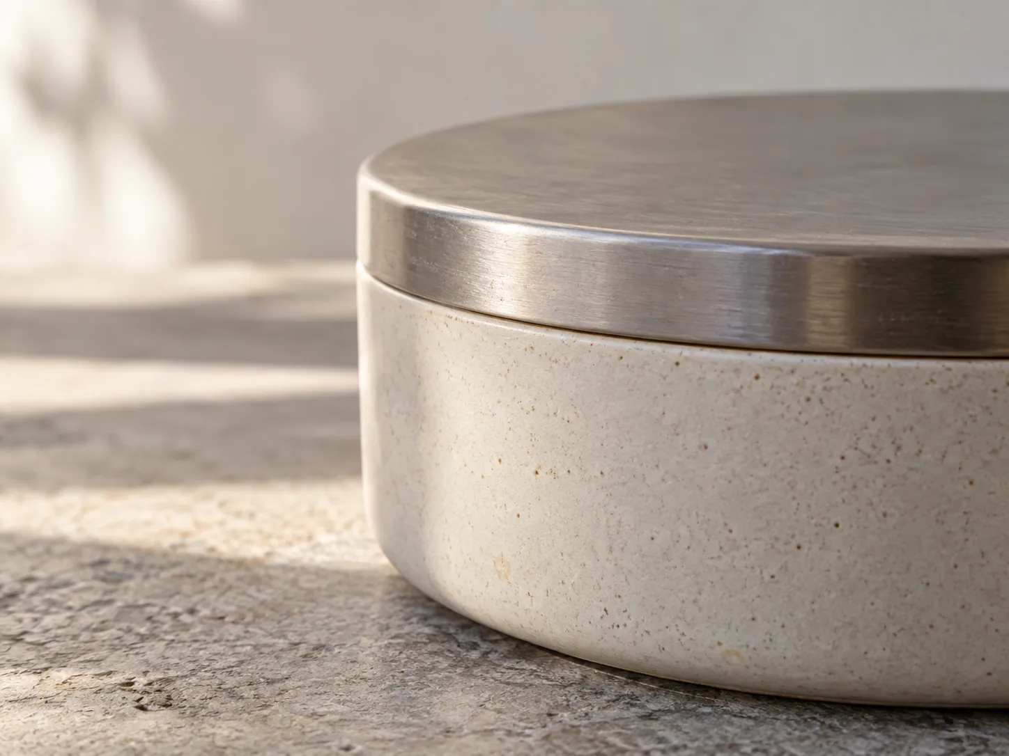 Ceramic and brushed metal forms meet at a precise, distinct interface.